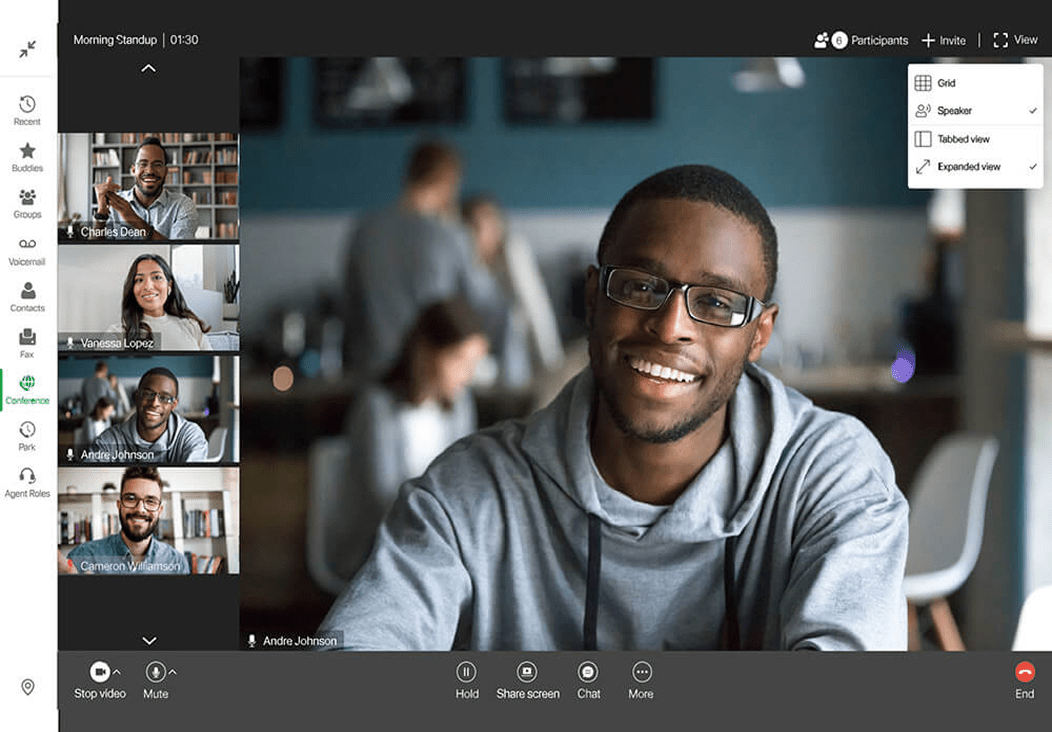 A smiling man in glasses and a gray hoodie is featured on a video call interface, with four other diverse participants visible in smaller windows on the left side of the screen. Video call controls and menu options are visible.